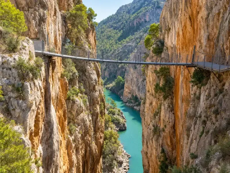 A narrow footbridge strung across the gorge between two rock walls