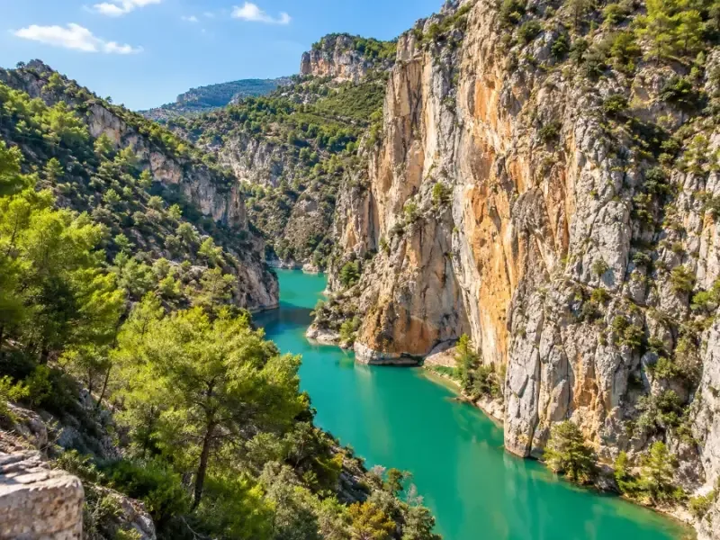 Turquoise reservoir water below pine-covered hills near the north access
